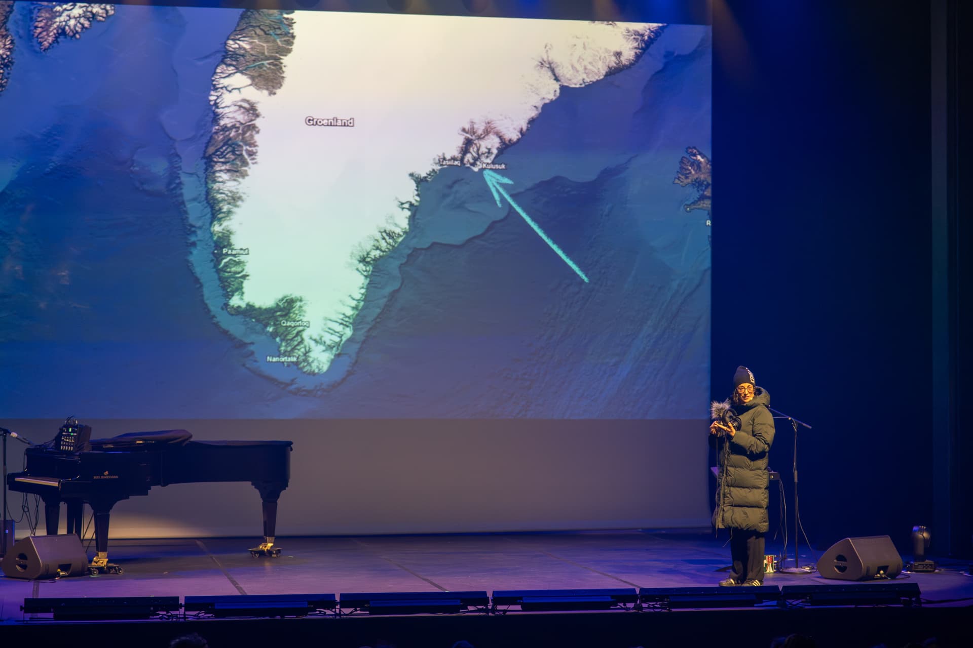 Récit documentaire devant une carte du Groenland projetée sur le plateau