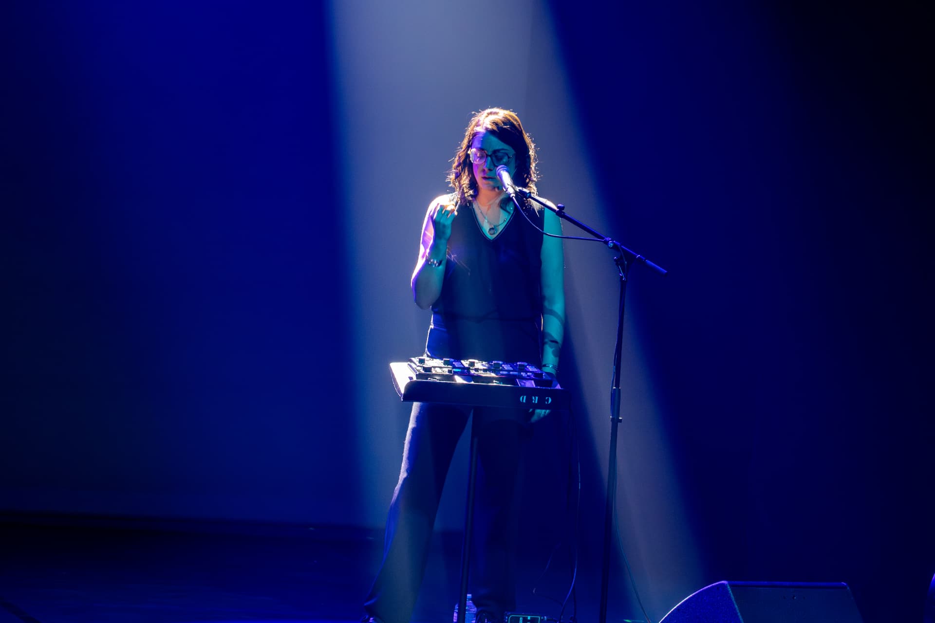L'artiste seule en scène, chant et clavier sous un faisceau de lumière