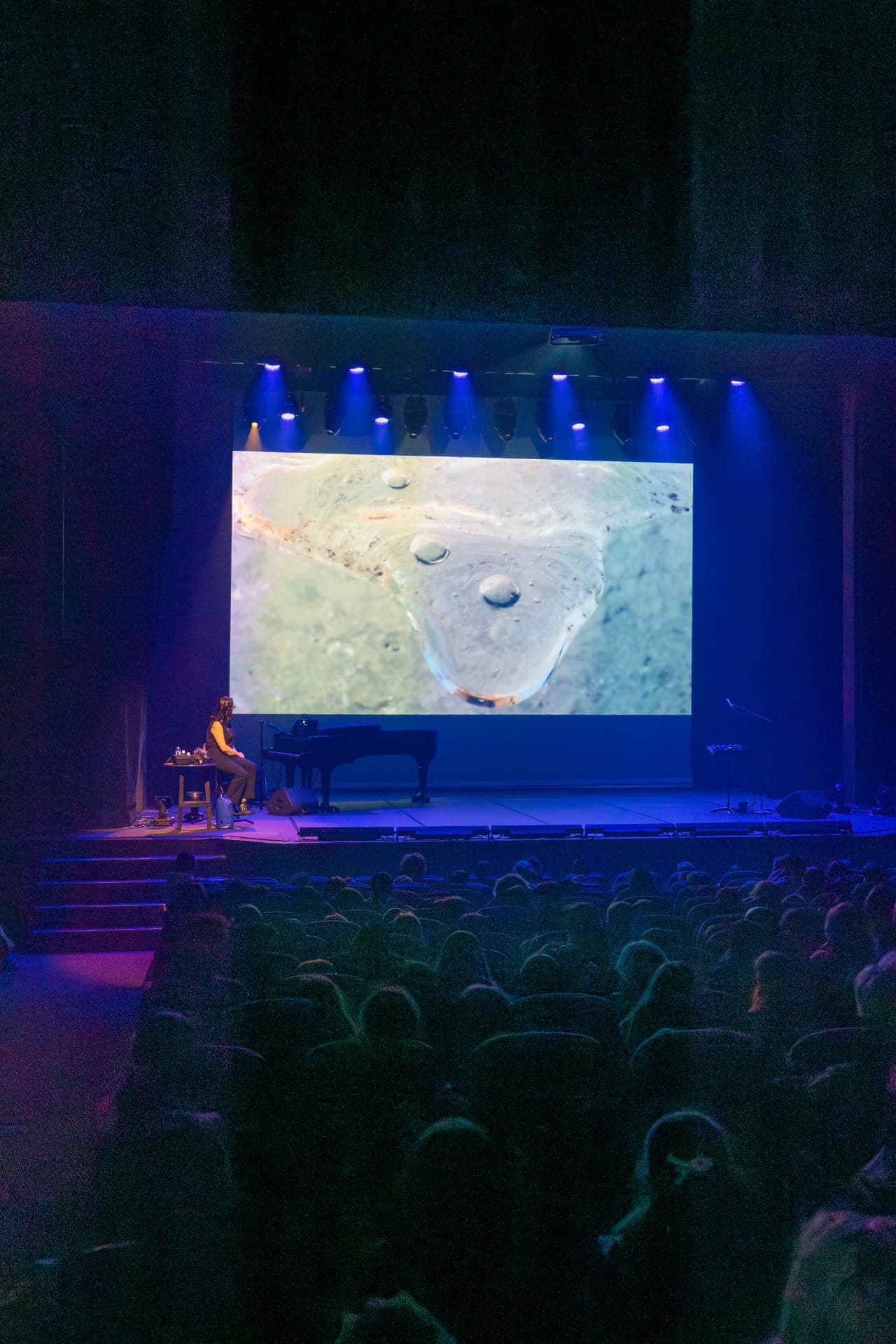Vue de salle : piano et grande projection sur le plateau